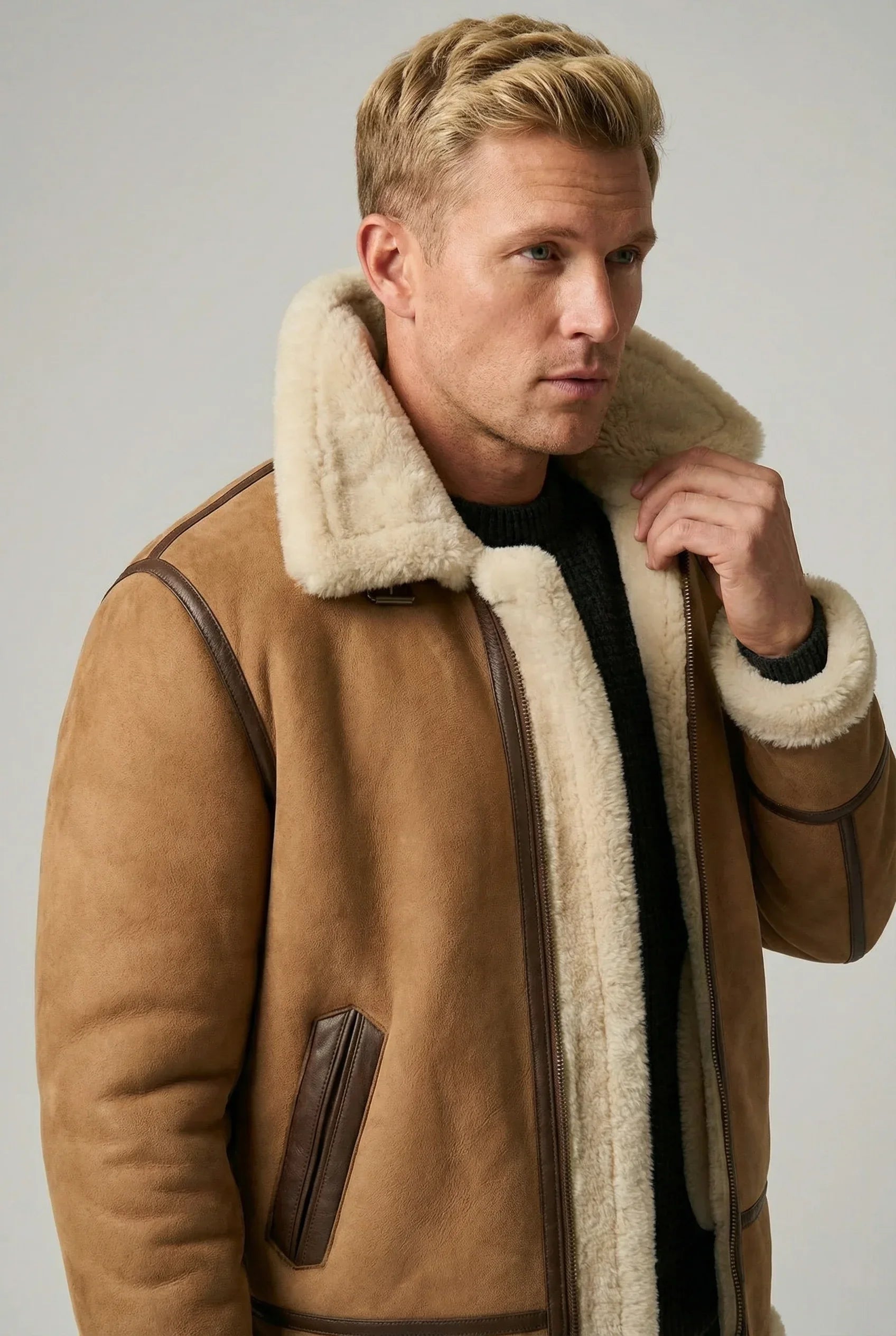 American man with blond hair wearing a Shearlord whiskey cream B-3 Bomber Jacket made of sheepskin shearling.
