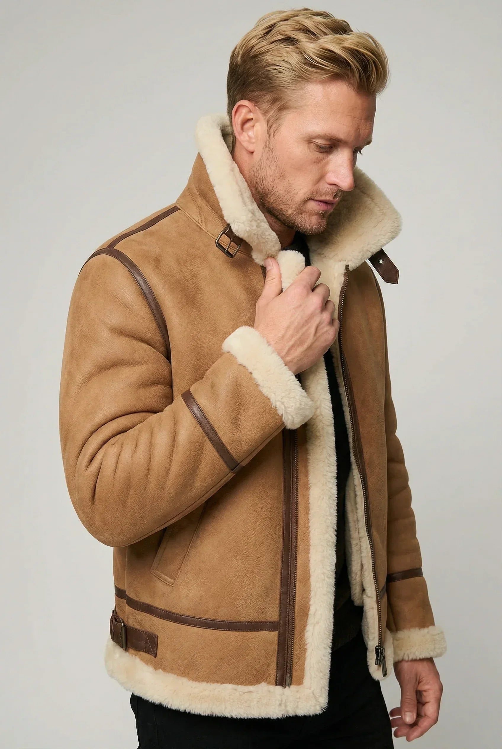 American man with blond hair wearing a Shearlord whiskey cream B-3 bomber jacket made of sheepskin shearling.